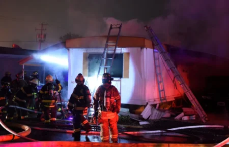 Firefighters at the scene of a fatal fire in Brice Villa mobile home park