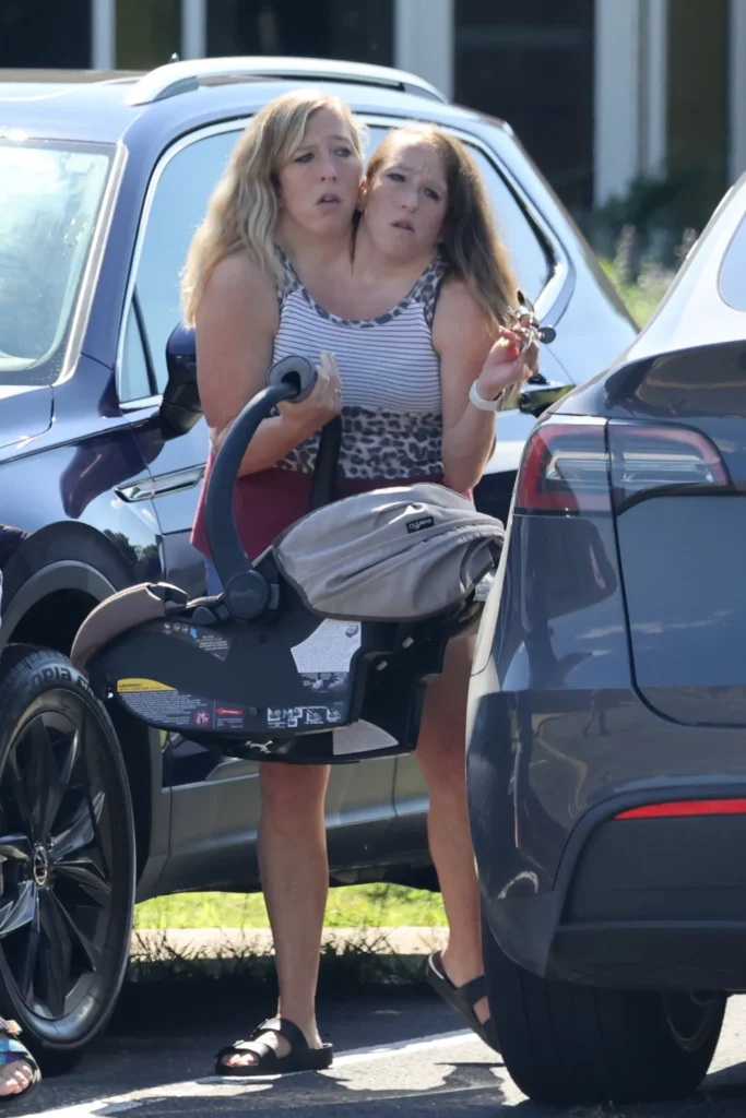 Abby and Brittany Hensel seen on August 27 with a newborn baby