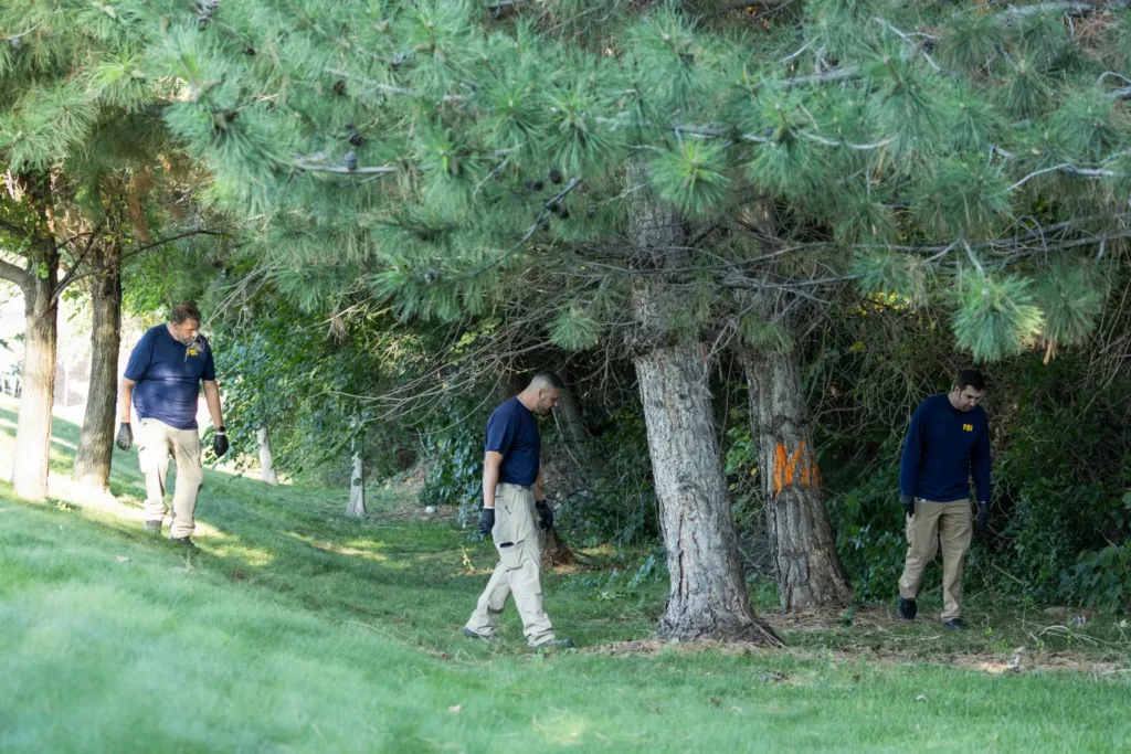 FBI agents search a wooded area near the scene of the shooting