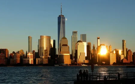 An 86 percent illuminated waxing gibbous moon rises behind the skyline of lower Manhattan and One World Trade Center