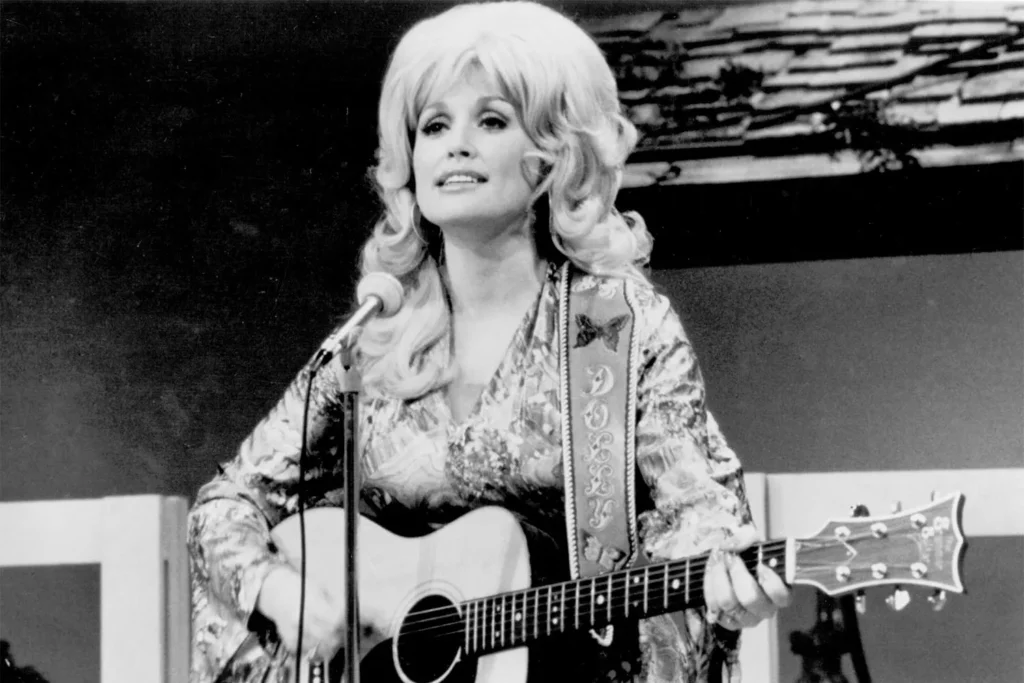 Country singer Dolly Parton performs onstage with an acoustic guitar in circa 1974.