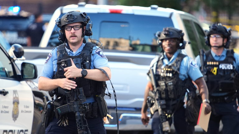Officers investigate the aftermath of a shooting in Minneapolis Wednesday.